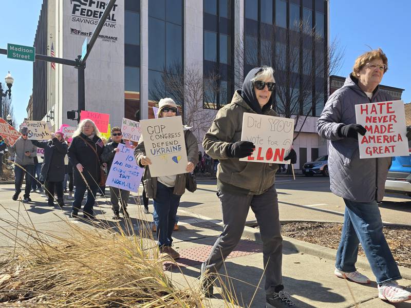 Several residents carried signs critical of Elon Musk's role in the Trump administration during the March for Democracy on Saturday, March 8, 2025, in downtown Ottawa.