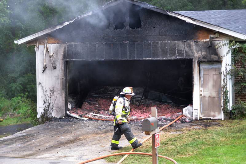 Mt. Morris Deputy Fire Chief Mark Lewis walks past the charred remains of an attached garage during a fire at 540 E. Elizabeth Road in rural Oregon on Wednesday, Aug. 20, 2025. Mt. Morris was one of four area departments that assisted Oregon firefighters on the call.