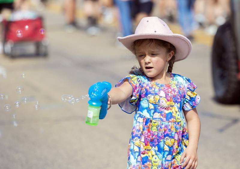 Malaina Herrera, 6, fires off bubbles while marching Saturday, Sept. 14, 2024, through the Fiesta Days parade.