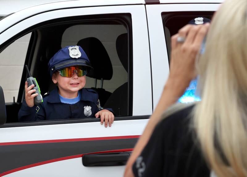 Leo Berres, 3, from Sycamore, has his picture taken in a Northern Illinois University Police vehicle Tuesday, Aug. 6, 2024, during National Night Out in the Hy-Vee parking lot in Sycamore.