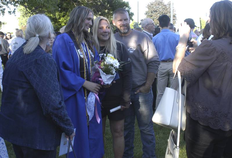 A crowd gathers to take photos with recent grads in the lawn outside Newman. The Newman High School Class of 2026 Commencement Ceremony was held on Wednesday, May 20, 2026, at Newman Central Catholic High School. in Sterling.