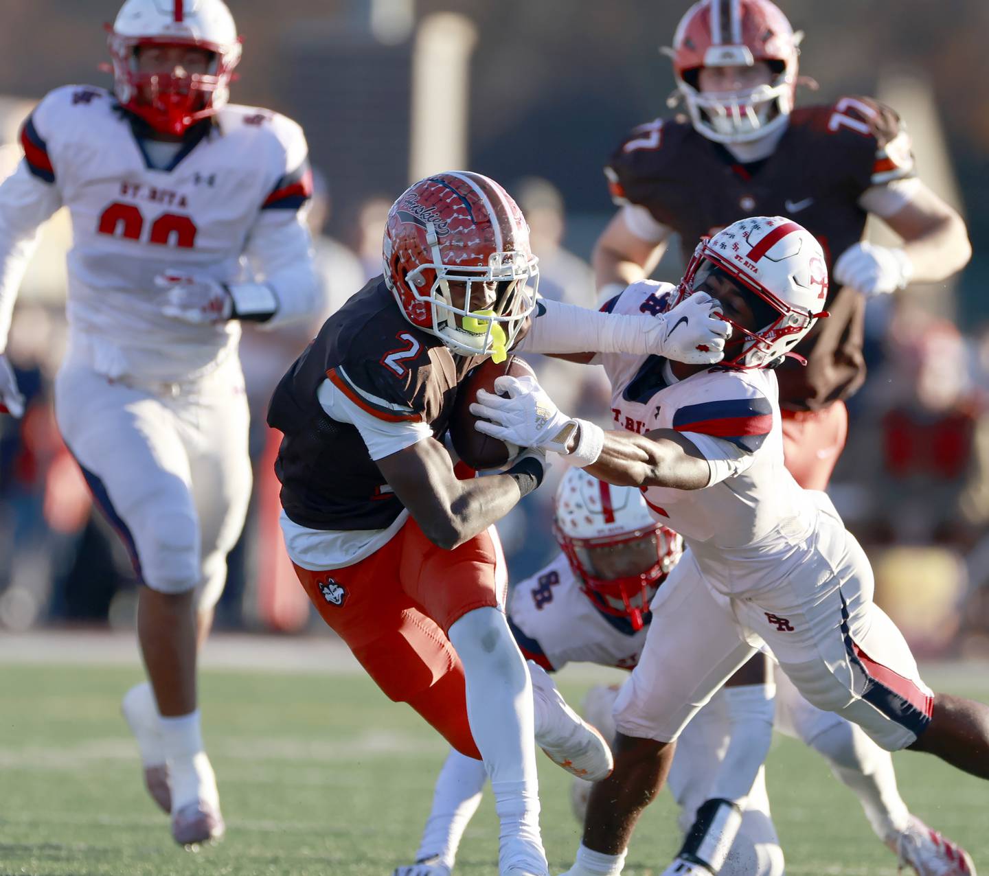 Hersey's Brandon Jenkins (2) pushes St. Rita's James Franklin Iii (2) out of the way during the IHSA Class 6A Football Quarterfinal Saturday, Nov. 15, 2025 in Arlington Heights.