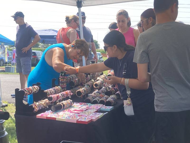 Visitors to the Shorewood Crossroads Festival visit a jewelry vendor's tent on Saturday, August 2, 2025.