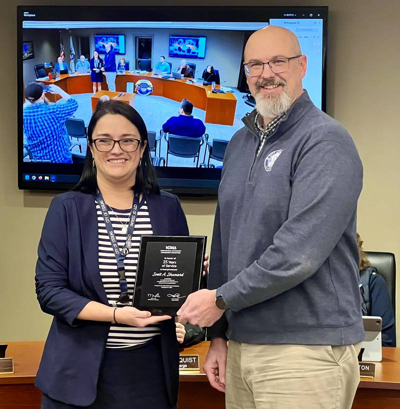 Sterling Mayor Diana Merdian presents an award to Scott Schumard honoring his 25 years of service as Sterling's City Manager.