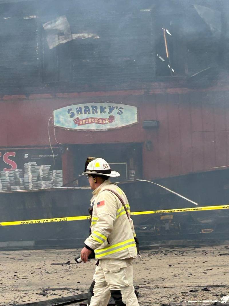 A firefighter walks past Sharky's in Mt. Morris on Tuesday, April 16, 2024.