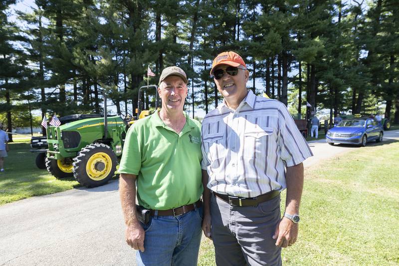 Ron Schulte (left) and Josh Francque started the tractor ride eight years ago as a way to celebrate God, country, family and neighbors. Despite the friendship, the two had to point out the green and red tractor rivalry. Schulte is a John Deere guy, while Francque is IH.