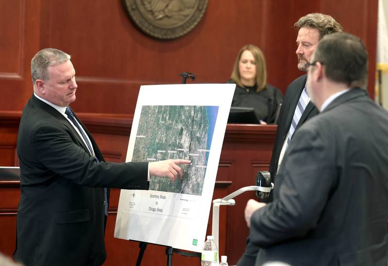 Retired DeKalb County Sheriff’s Detective John Holiday points to locations on a map Monday, Jan. 27, 2025, as lead prosecutor Scott Schwertley (second from right), lead defense attorney Chip Criswell and Circuit Court Judge Marcy Buick look on during the trial of Jonathan D. Hurst at the DeKalb County Courthouse in Sycamore. Holiday testified about the route a stolen car owned by Patricia Wilson traveled from Sycamore to Chicago. Hurst is charged in the 2016 killings of Patricia and her son, Robert Wilson.