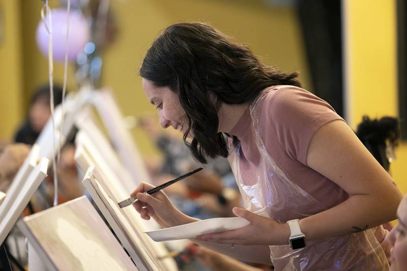 Alexis Ruiz of Sterling gets a better angle for her portrait Monday, April 15, 2024 during the Selena paint party.