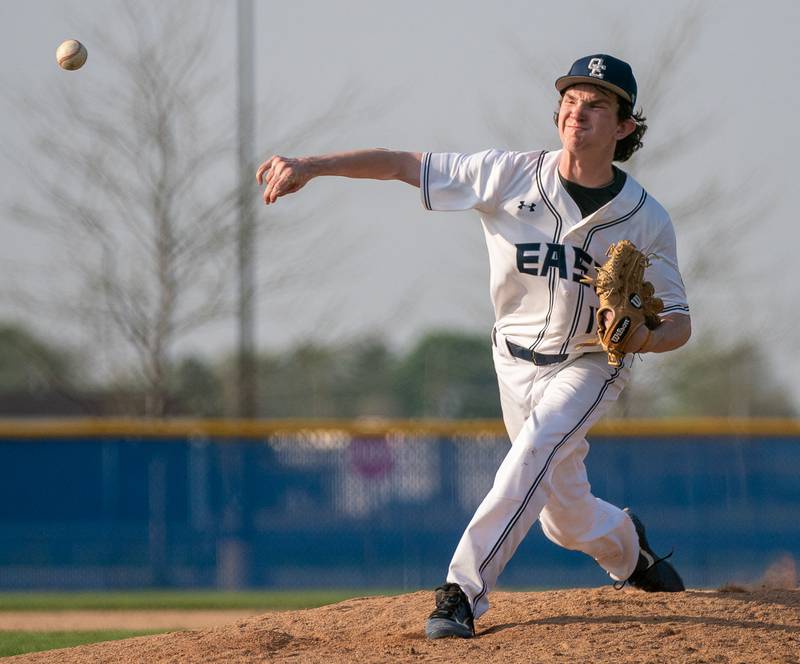 Oswego East's Patrick Flynn (12) delivers a pitch against Oswego during a baseball game at Oswego East High School on Tuesday, May 10, 2022.