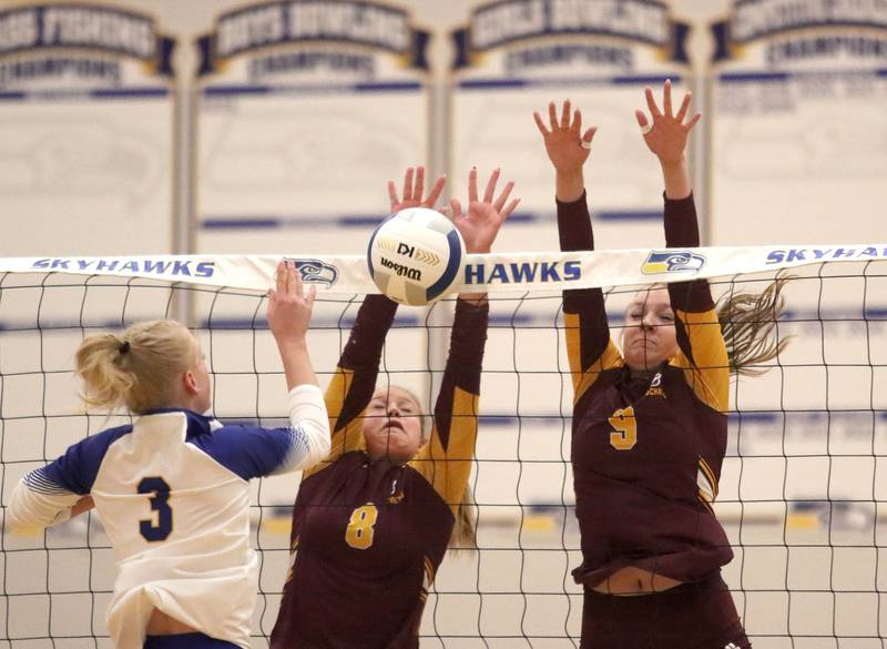 Richmond-Burton’s Adelynn Woods, center, and Reagan Wisniewski, right, block Johnsburg’s Alexis Sweetwood in varsity girls volleyball at Johnsburg High School in Johnsburg on Thursday, August 25, 2025.