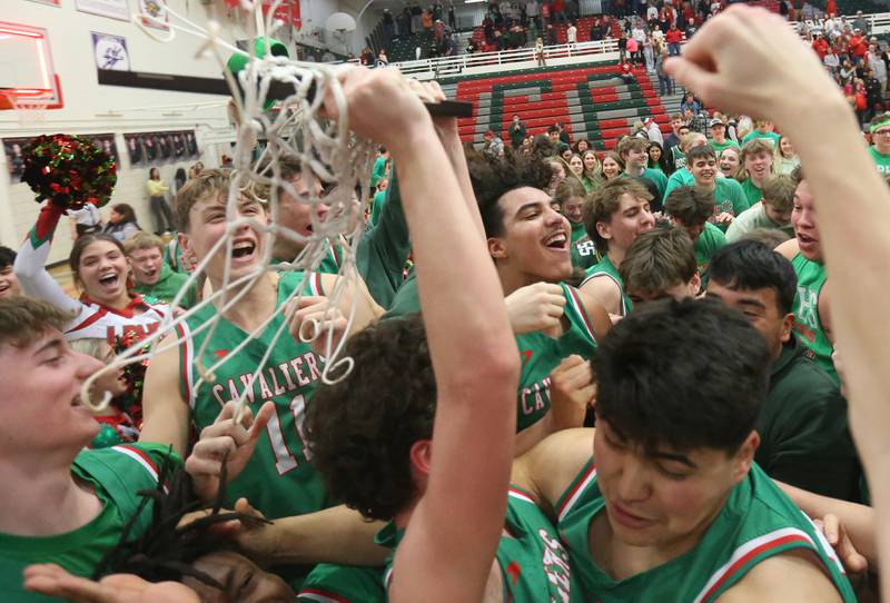 Members of the L-P boys basketball team hoist the Class 3A La Salle-Peru Regional title plaque after defeating Streator on Friday, Feb. 28, 202,5 in Sellett Gymnasium at L-P High School.
