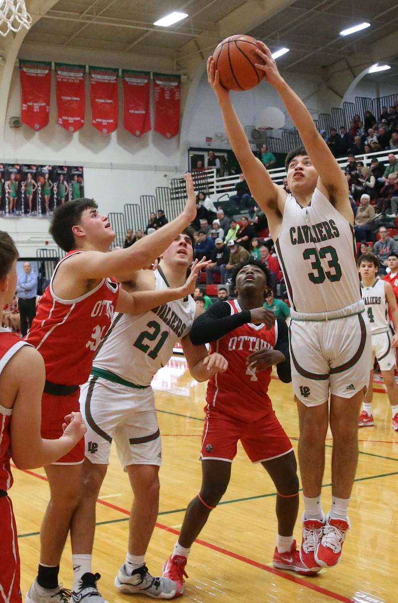 L-P's Eric Sotelo grabs a rebound over Ottawa's Kooper Knoll, and Keevon Peterson on Friday, Jan. 5, 2024 at Sellett Gymnasium.