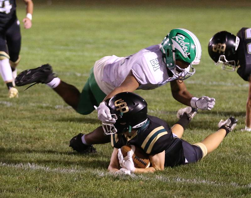 Ridgewood's Julian Luna grabs the helmet of St. Bede's Carson Riva as he falls to the ground on Friday, Sept. 15, 2023 at St. Bede Academy.