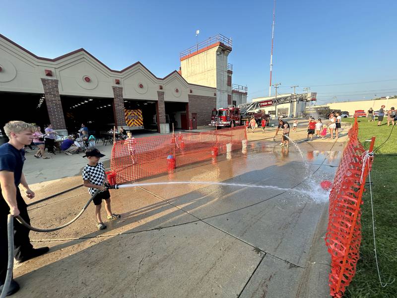 Kids take part in a water hose skill battle compliments of the Byron Fire Department at the Ogle County Sheriff's Department and Byron Police Department's National Night Out in Byron  on Tuesday, Aug. 5, 2025. Other agencies also took part in the evening event.