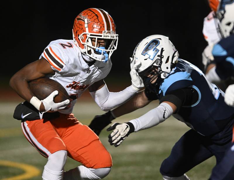 Hersey’s Brandon Jenkins, left, ties to get past Prospect’s Charles Letzig during a class 7A first-round football playoff game on Friday, Nov. 1, 2024 in Mount Prospect.