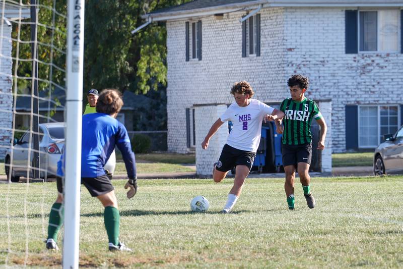 Manteno's Gio Arrigo crosses the ball toward the goal under pressure from Bishop McNamara's Diego Perez during the Panthers' 10-0 victory over Bishop McNamara on Monday, Sept. 8, 2025.
