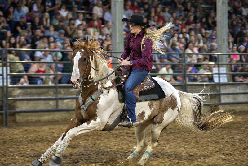 Morgan Franzen approaches the last of three barrels during the barrel racing event at the Rice Bull Riding rodeo at the 2021 Carroll County Fair.