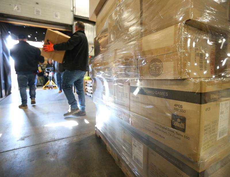 Illinois Valley Building Trades workers carry toys onto the loading dock at DD Warehouse on Thursday, Dec. 1, 2022 in Peru.