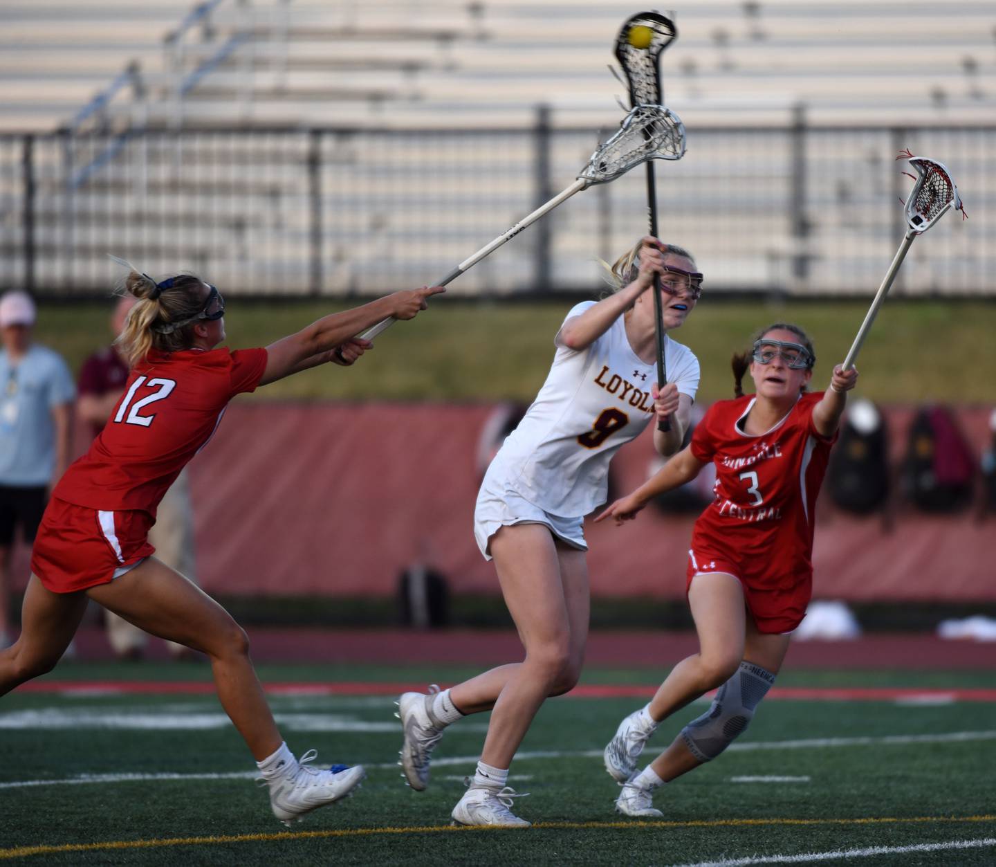 Joe Lewnard/jlewnard@dailyherald.com
Loyola Academy’s Eileen Dooley scores as she gets between Hinsdale Central’s Ari Tavoso, left, and Amelia Sowers during the girls state lacrosse championship in Hinsdale Saturday.
