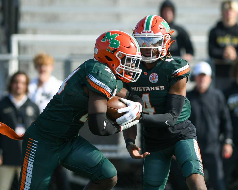 Morgan Park’s Marcus Thaxton (4) hands the ball off to teammate Morgan Park Keshawn Lewis-Hunt (24) during the first quarter on Saturday Nov. 4, 2023, while taking on Sycamore at Gately Stadium in Chicago