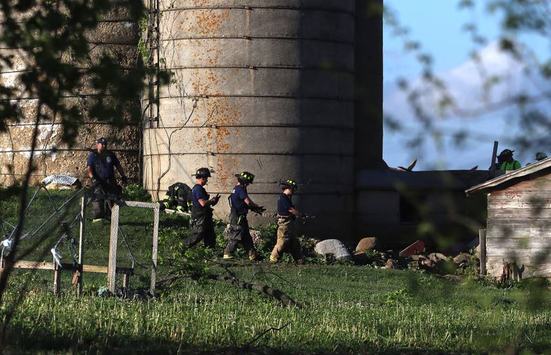 First responders and property owners tend the scene of a barn collapse along Weidner Road near Harvard on Tuesday evening.