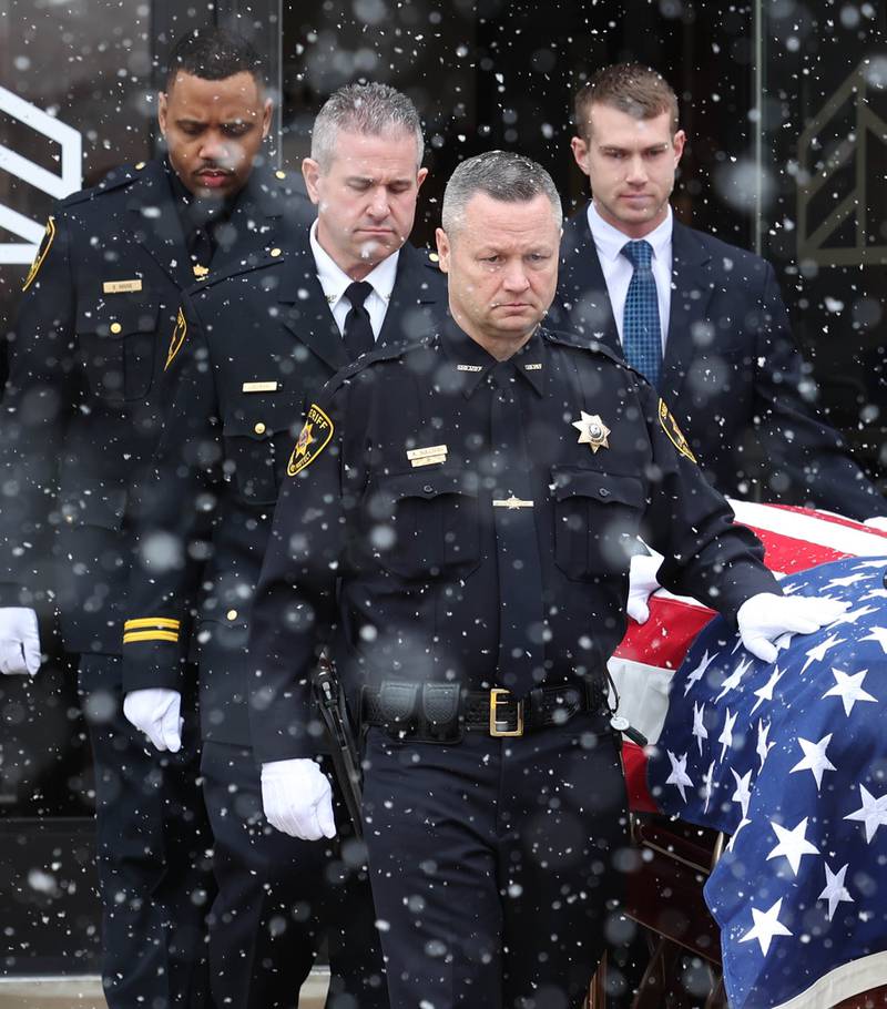 Current DeKalb County Sheriff Andy Sullivan places his hand on the casket of former DeKalb County Sheriff Roger Scott as it is brought out Friday, March 7, 2025, following his memorial service at Bethany Road Bible Church in DeKalb. Scott, who was the county sheriff for 36 years, died on February 23 at the age of 78.