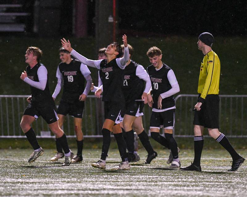 Prairie Ridge's Logan Braun (2) throws his hands up in celebration while teammates smile after Nicolas Flaugher’s scores a goal while taking on Benet Academy during the class 2A super sectional soccer match on Tuesday Nov. 5, 2024, held at Wheaton Academy in West Chicago.