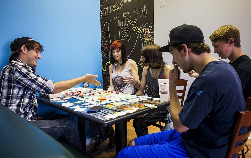 Patrick Predergast, 21 (from left), Karolyn Seredick, 18, Ray Merkel, 18, Kyle Howell, 16, and Andrew Koenig, 18, play monopoly Wednesday, June 18, 2014, at the Break teen center in Crystal Lake, shortly after it opened.