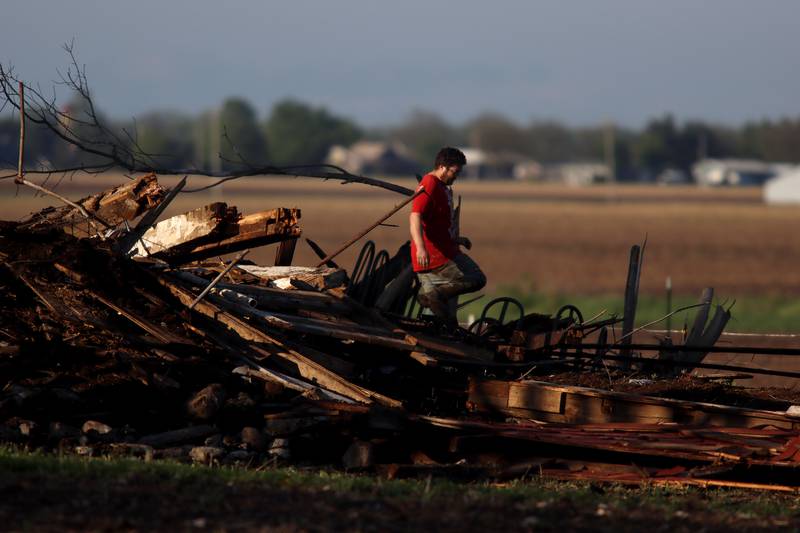 First responders and property owners tend the scene of a barn collapse along Weidner Road near Harvard on Tuesday evening.