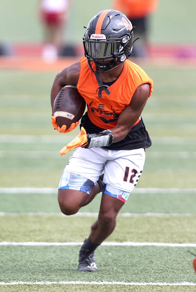 DeKalb's Xavier Dandridge carries the ball Monday, Aug. 8, 2022, at the school during their first practice ahead of the upcoming season.