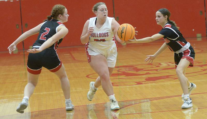 Henry-Senachwine’s Brynna Anderson and Bella Williams work to seize control of the ball from Streator’s Maddy Martin in the 2nd period Tuesday at Streator.