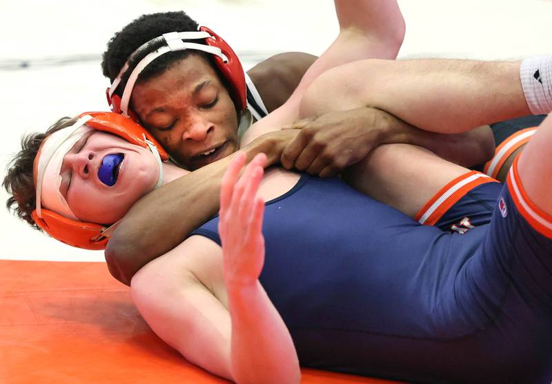 DeKalb’s Mekhi Cave works to pin Naperville North’s Clayton Champion in their 138 pound semifinal match Friday, Jan. 20, 2023, during the DuPage Valley Conference wrestling tournament at DeKalb High School.