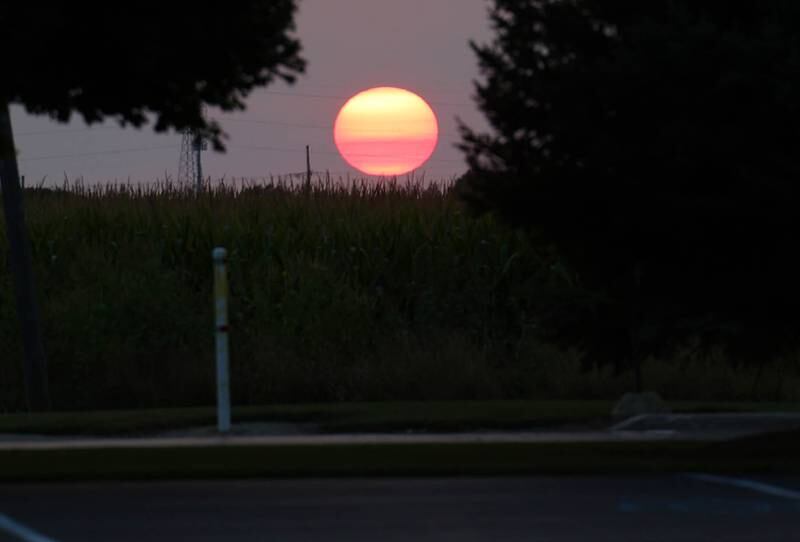 The sun sets Wednesday, Sept. 11, 2024, over the parking lot at Genoa-Kingston High School.