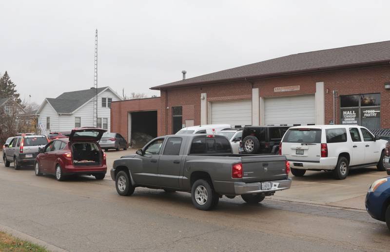 A long line of cars wrap around the building during the Thanksgiving distribution on Wednesday, Nov. 19, 2025 at the Hall Township Food Pantry in Spring Valley. Nearly 500 families will receive food from this years distribution.