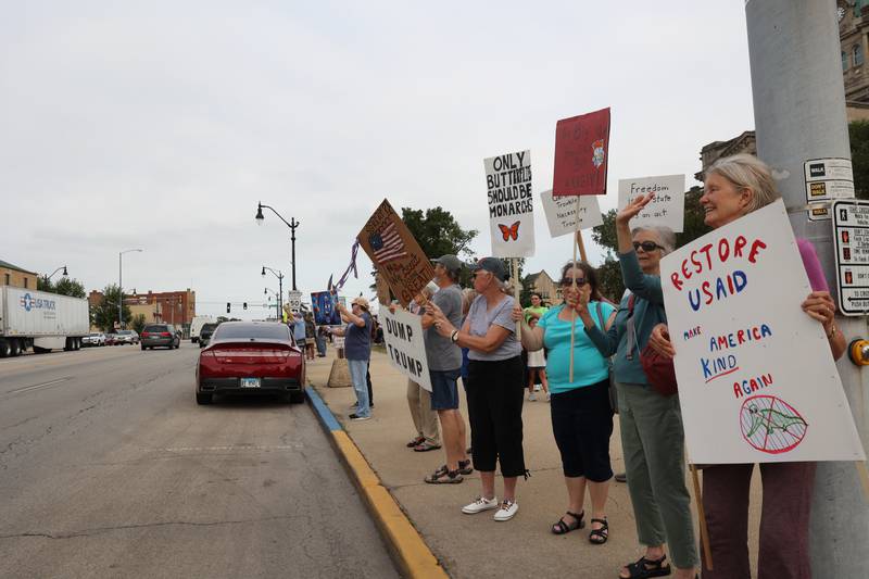Protesters hold signs along East Court Street during a "Good Trouble Lives On" rally held in Kankakee as part of a national day of peaceful protests on Thursday, July 17, 2025.