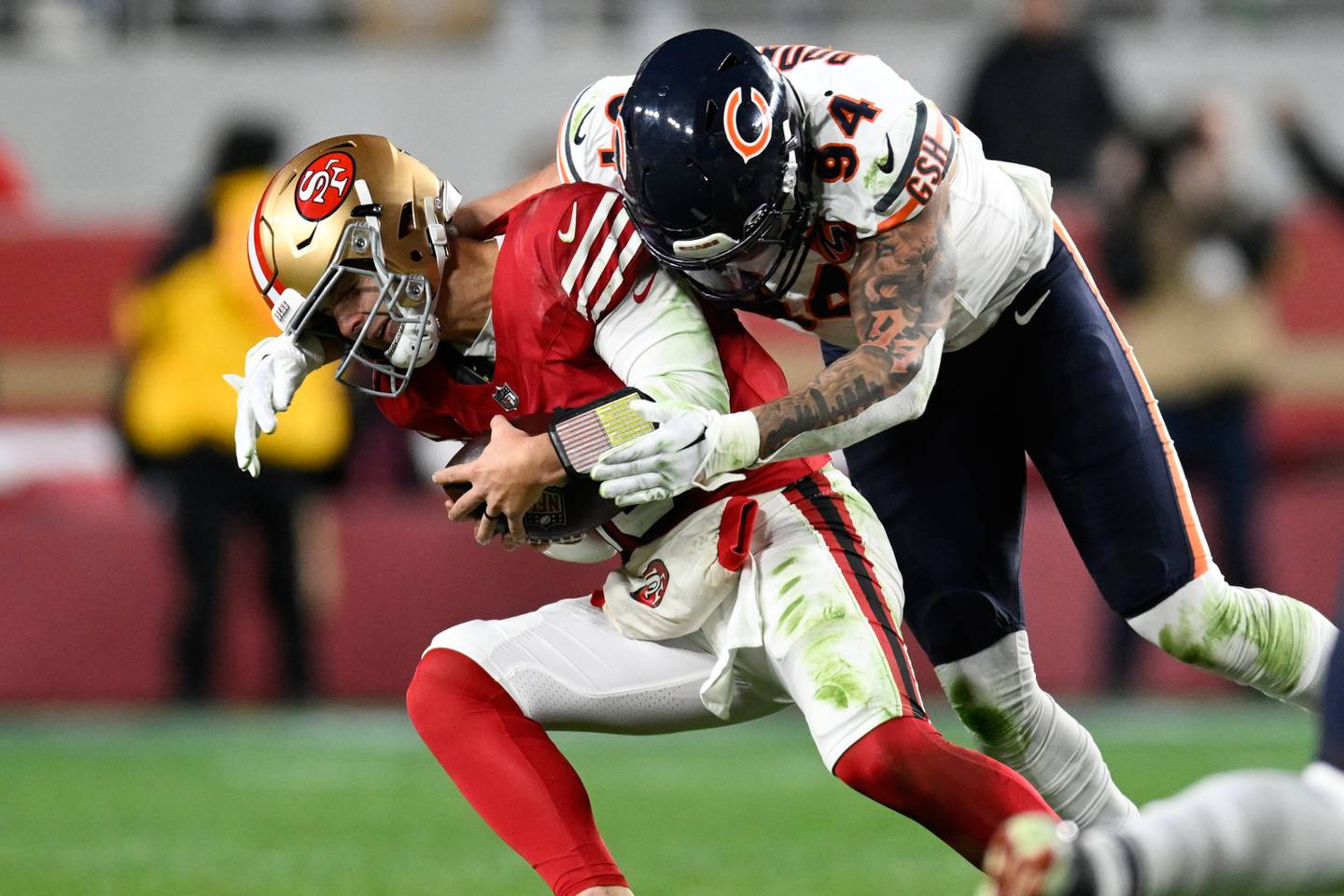 San Francisco 49ers quarterback Brock Purdy, left, is tackled by Chicago Bears defensive end Austin Booker during the first half of an NFL football game in Santa Clara, Calif., Sunday, Dec. 28, 2025. (AP Photo/Eakin Howard)