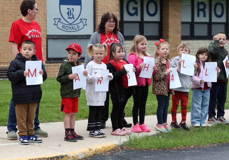 Students from Hinckley-Big Rock Elementary School hold signs Monday, May 5, 2025, outside of the school as they await the arrival of Marshall Morong, 7, a first grader, for his first day back following months waiting for, and eventually receiving, heart transplant surgery at Lurie Children’s Hospital of Chicago. Morong arrived in style in a Tesla Cybertruck donated for use by Telsa of Naperville, along with an escort by Hinckley and Big Rock first responders.