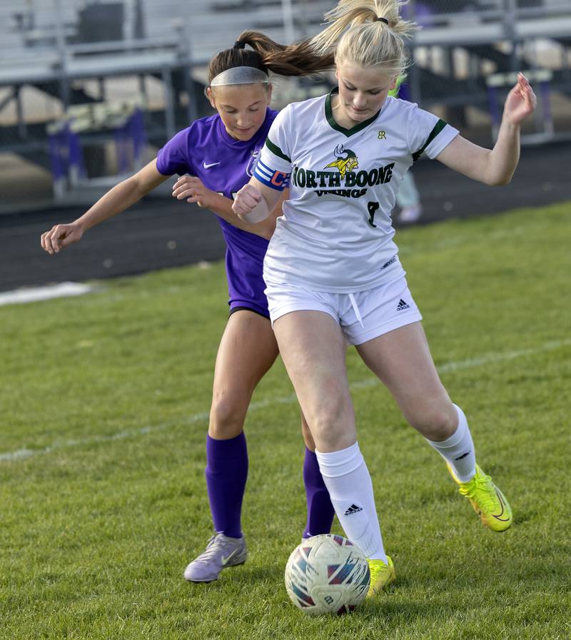 Dixon’s Jenna Harrison works and North Boone’s Mia Swenson fight for the ball Tuesday, April 15, 2025.
