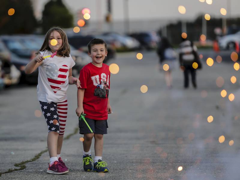Madison, 7, and Brady, 4, Fleck watch a sparkler before a Fourth of July fireworks show in Joliet on Friday.