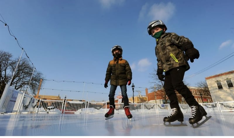 Brothers Owen Hyland, 5, right, and Aidan, 8, of Wheaton show off their skating skills on the new ice skating rink in downtown Glen Ellyn. Mom, Lisa Hyland, also donned her skates. Mark Welsh | Staff Photographer