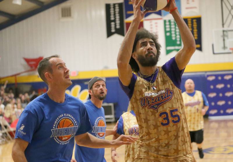 Harlem Wizards player Tyler Cronk runs in to score overLogan Jr. High superintendent Tim Smith during the Harlem Wizards event on Tuesday, Oct. 28, 2025 in Pannebaker Gymnasium at Logan Jr. High School in Princeton.