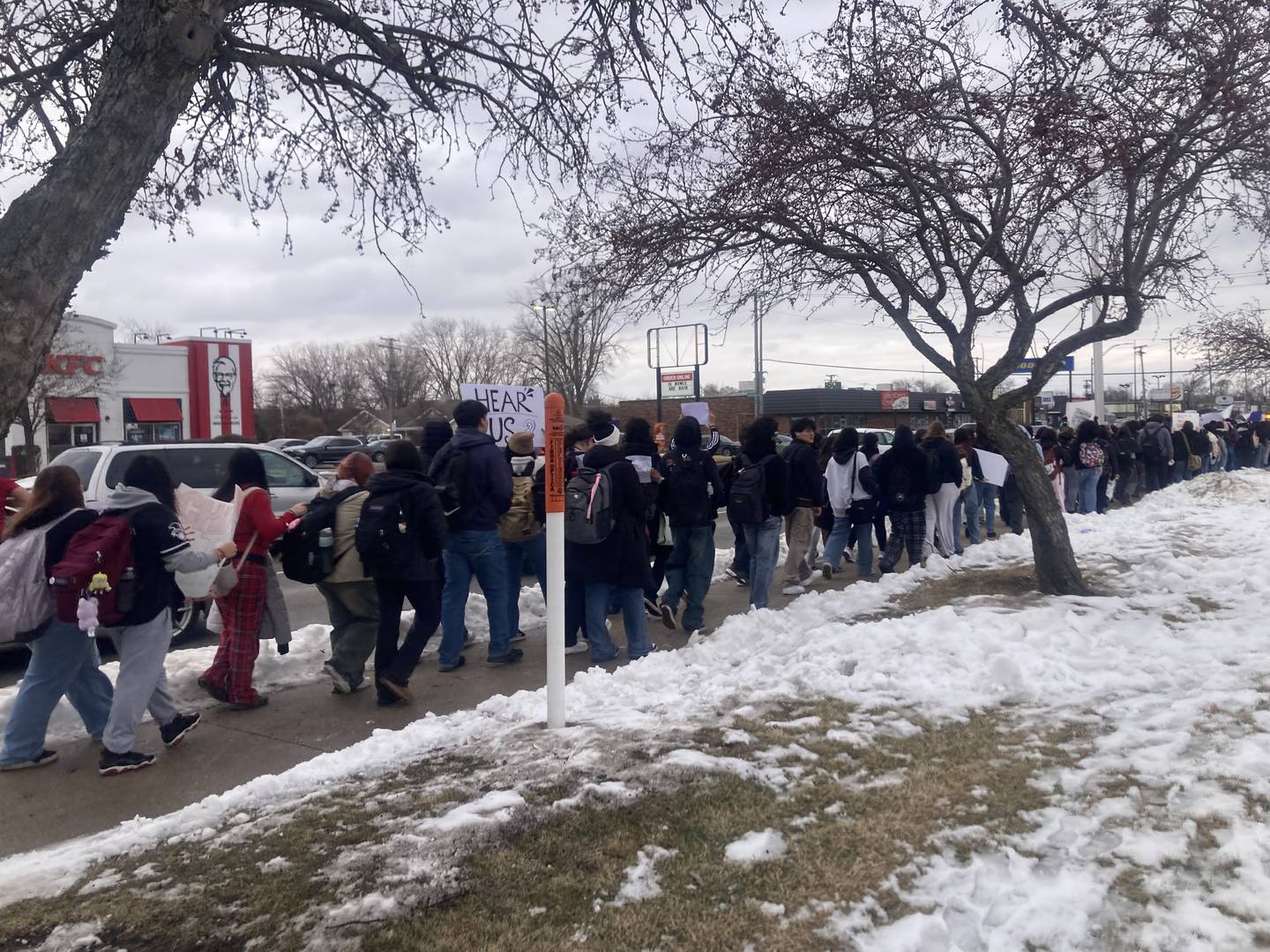 Students from Joliet West High School hold signs as they march down Larkin Avenue after walking out of school to protest the actions of Immigration and Customs Enforcement agents on Friday, Feb. 6, 2026.