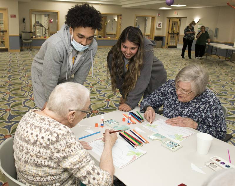 Timbers of Shorewood residents Gert Kremer and Maxine Ahern work on their painting with Dakota Joachim and Andrea Villa from University of St. Francis Recreation and Sport Management program at Timbers of Shorewood Wednesday, April 19, 2023, in Shorewood, Ill.