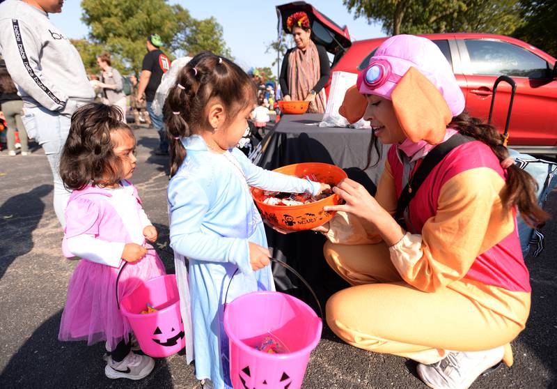 Yaritza (left) and Evelyn Fuogencio of Hodgkins get candy from Claire McCarthy with Seaspar on Saturday, Oct. 12, 2024 during a Trunk or Treat event at Sedgwick Park in La Grange.