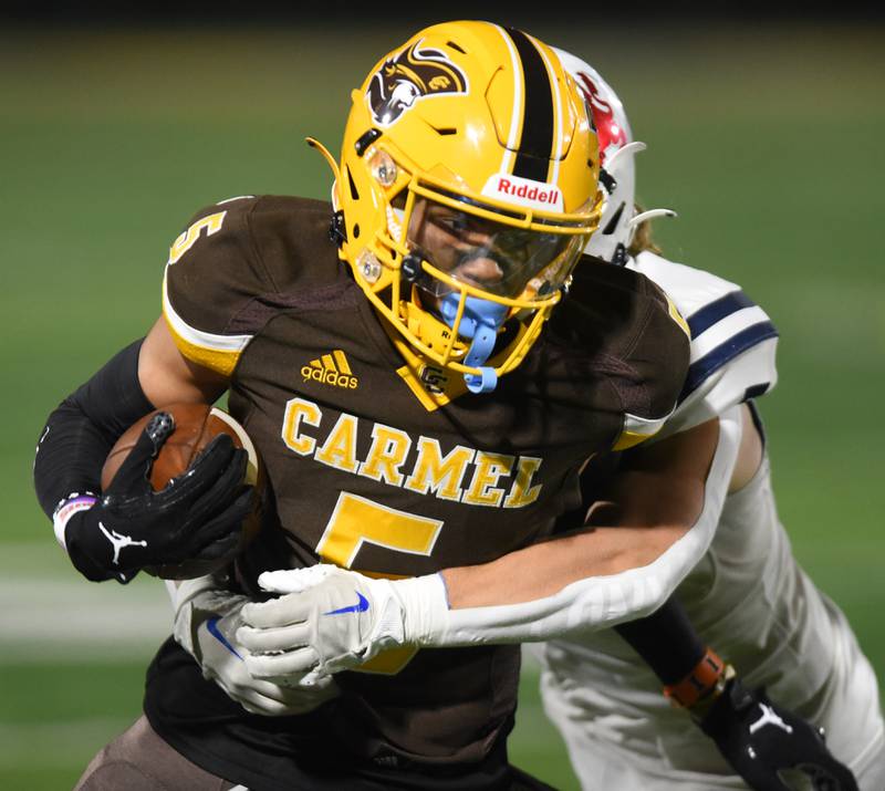 Joe Lewnard/jlewnard@dailyherald.com
Carmel’s Jarren Black, front, gets tackled by St. Viator’s Michaeel Tauscher during Friday’s game in Mundelein.