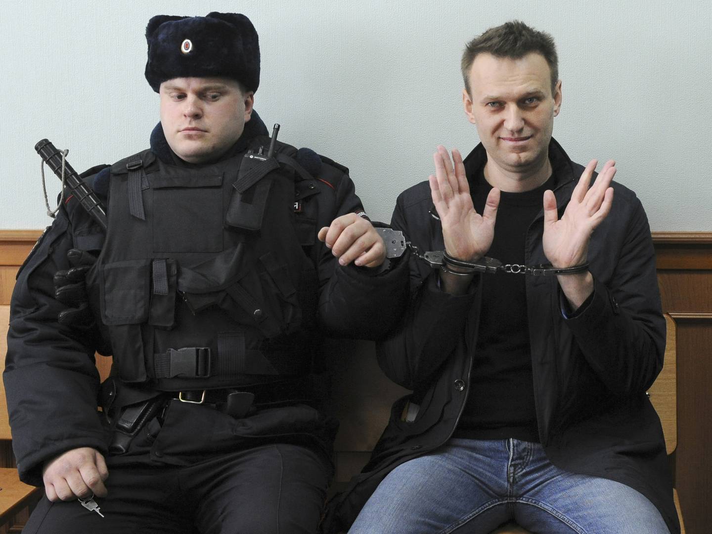 FILE - Russian opposition leader Alexei Navalny, right, poses for press as he sits handcuffed in court in Moscow, Russia on March 30, 2017. Russia’s prison agency says that imprisoned opposition leader Alexei Navalny has died. He was 47. The Federal Prison Service said in a statement that Navalny felt unwell after a walk on Friday Feb. 16, 2024 and lost consciousness.