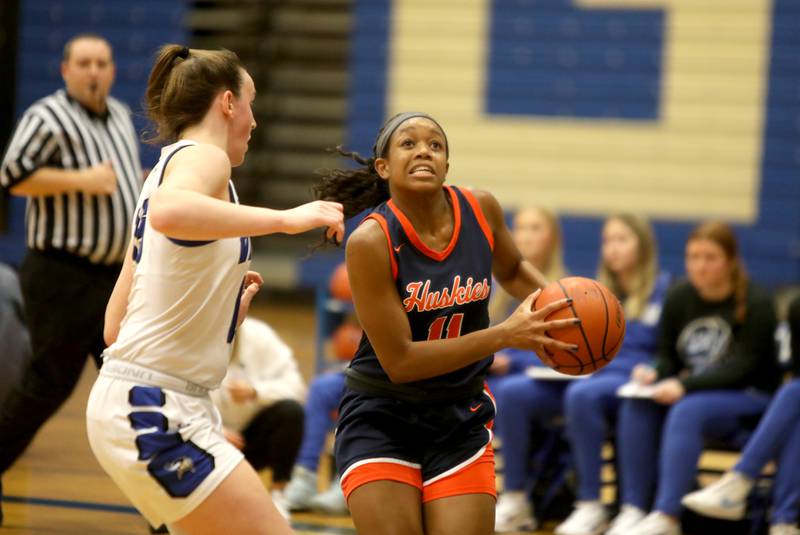 Naperville North’s Layla Henderson drives toward the basket past Geneva’s Cassidy Arni during a game at Geneva on Tuesday, Nov. 29, 2022.