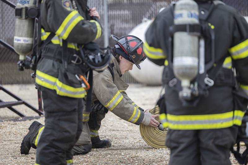 Alex Biden, 19, of Sublette, rolls up a hose Saturday, March 15, 2025, during cadet firefighter training in Amboy.