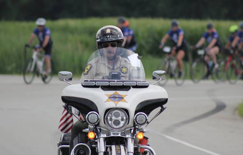 An Illinois State Police trooper helps safely escort nearly 100 cyclists biking from Normal, through La Salle County to DeKalb on Saturday, July 12, 2025, for Cycle Across Illinois, a charity campaign to honor fallen police officers and raise funds for their families.