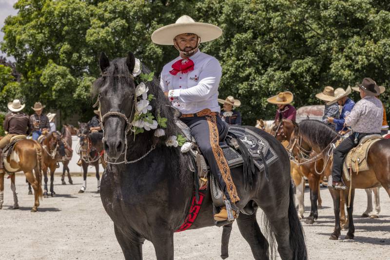 Jose Mondragon and his horse pose for a photo Sunday, June 2, 2024, prior to the start of the Corpus Christi procession in La Salle.